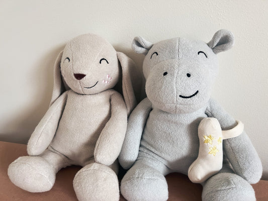 Organic cotton stuffed animal bunny and hippo friends sitting beside each other.