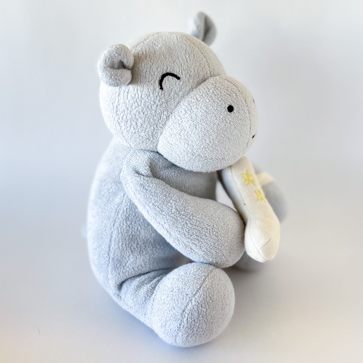 side view of light blue hippo plush toy with embroidered features
