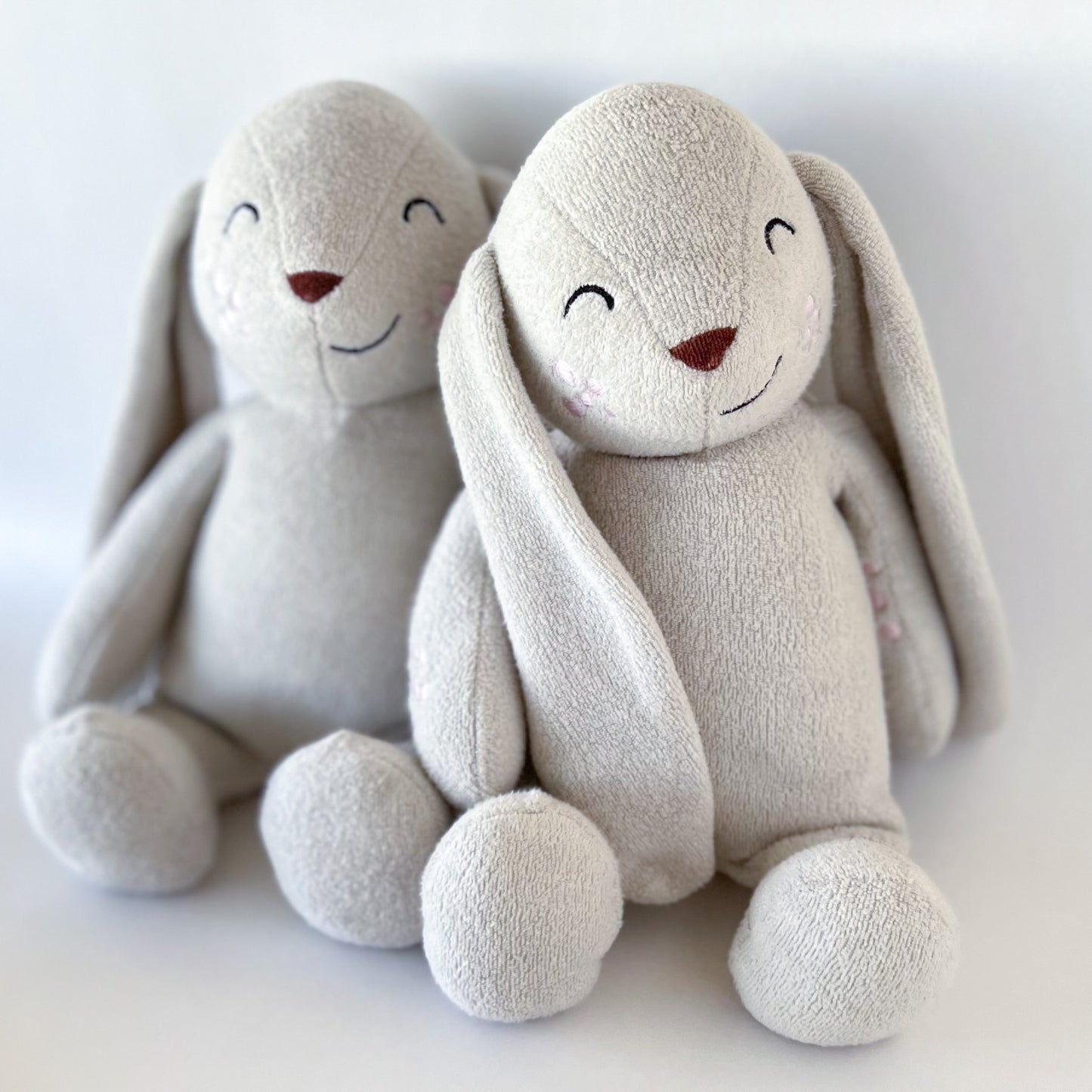 two stuffed animal bunnies sitting together