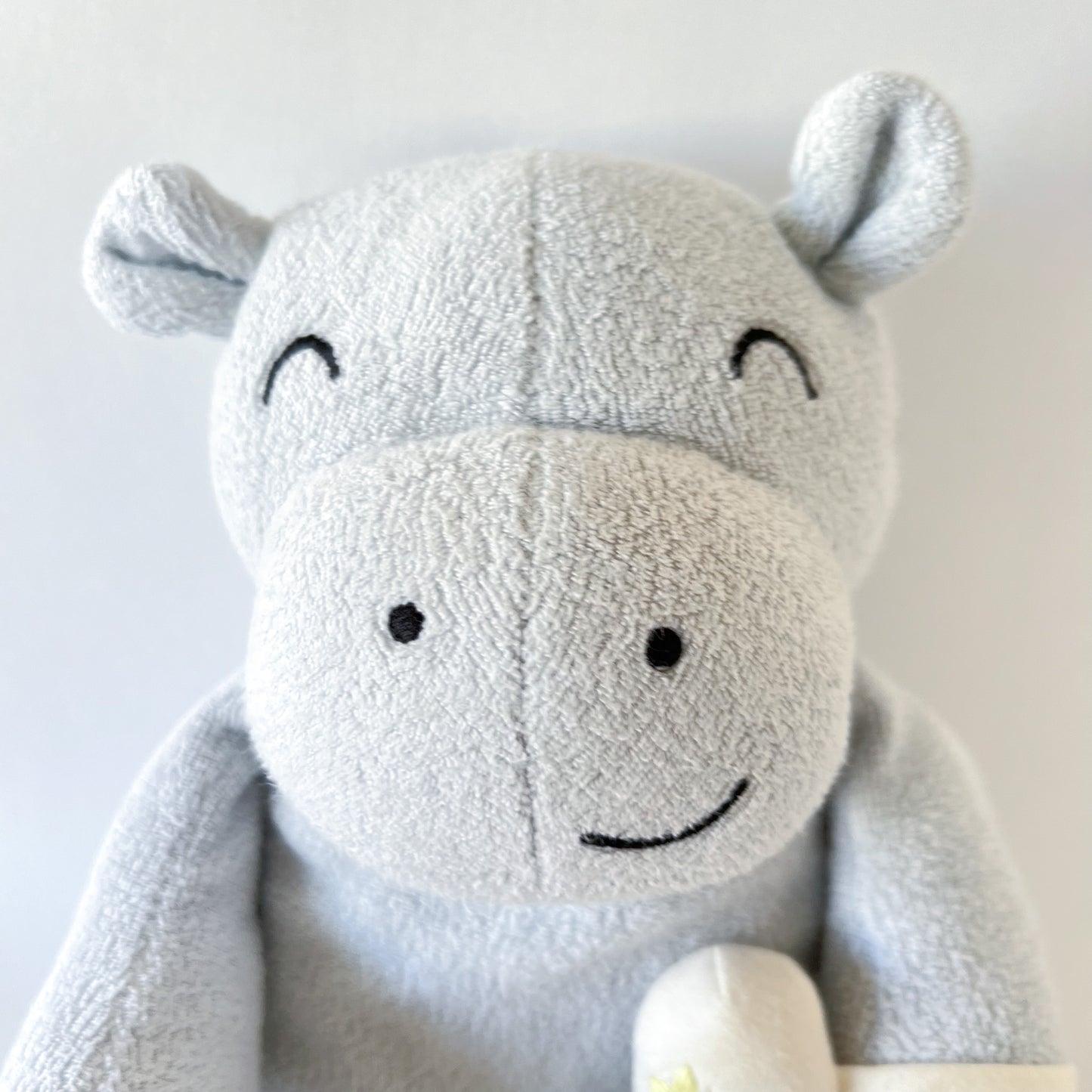 close up shot of stuffed animal hippo face showing embroidered facial features