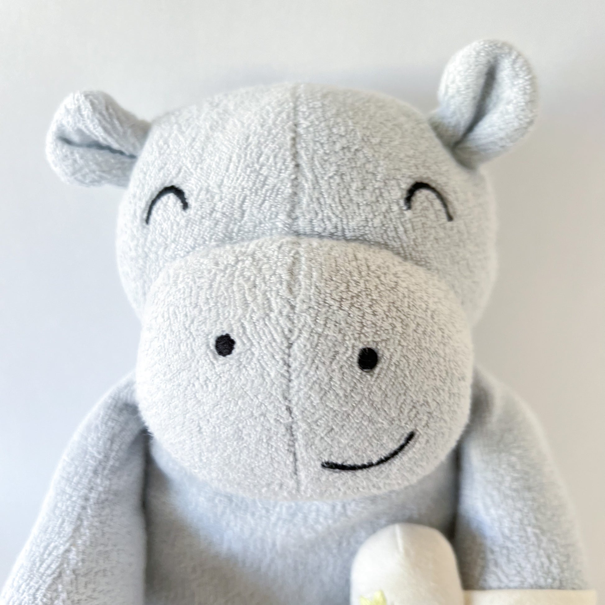 close up shot of stuffed animal hippo face showing embroidered facial features